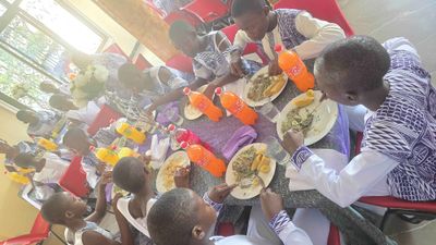 Students sharing a meal together around a long table in the refectory